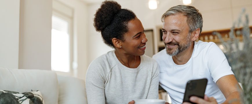 Couple Smiling at Each Other with a Phone